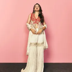 A full length view of the red and white embroidered sharara set. The combination of a fitted jacket with flowing pants is a contemporary silhouette I often recommend for festive events.
