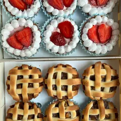 A box of our assorted mini tarts, featuring fresh strawberry tarts and classic apple pies with a beautiful lattice crust. Perfect for dessert tables or as a shareable treat.