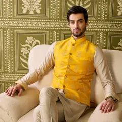 Another take on the perfect Haldi look. This mellow yellow waistcoat features subtle, self-colored embroidery, worn over a beige kurta for a refined and elegant appearance.