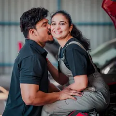 Love isn't always glamorous; sometimes it's about being partners in everything. This playful shot from a car garage themed shoot captures a fun, candid moment and a unique love story.
