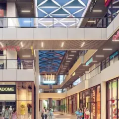At AIPL Joy Central in Gurugram, the design is planned around an open-to-sky courtyard that fills the retail environment with natural light. The geometric ceiling patterns add visual interest while softening the built mass.