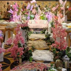 A view of the Sangeet seating area, where the aisle is lined with whimsical pink cherry blossom trees. The decor continues the fairytale garden theme, leading guests towards the magical stage.