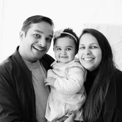 A classic black and white family portrait. The family's bright smiles are the centerpiece of this happy and timeless image.