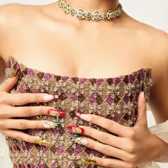 This custom nail set was designed to perfectly match the intricate, traditional embroidery of the outfit. I used a mix of red, green, and gold chrome to create a royal look for this editorial shoot.