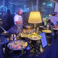 Another view of our bustling live pasta and Asian stir-fry stations. These interactive counters are always a highlight, creating a vibrant atmosphere and allowing guests to engage with our chefs.