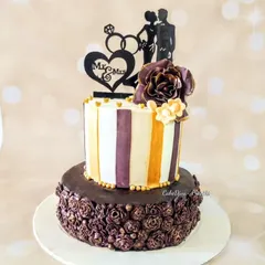 This unique engagement cake uses a bas-relief technique on the bottom tier, where the chocolate roses are raised just slightly from the surface. The top tier features clean stripes, creating a modern and artistic look.