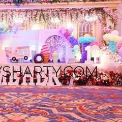 The main stage of the Candyland party, featuring a sweet shop backdrop, an ice cream truck prop, and large marquee letters.