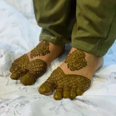 This designer foot henna features a bold central pattern with delicate jaali (net) work covering the toes. It's a modern take on traditional foot mehndi.