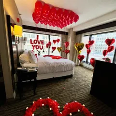 A wider view of our classic romantic setup, showing a rose petal heart pathway leading to the beautifully decorated bed. This gives you a sense of how we transform the entire space.