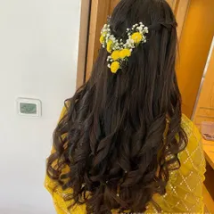I created this fresh and simple half-updo for a Haldi ceremony, using bright yellow flowers and baby's breath to complement the bride's yellow outfit.