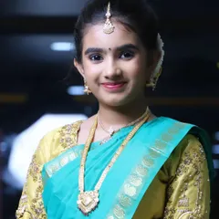 A close-up portrait of Niharika. You can see the soft eye makeup and natural lip color that complements her green and gold outfit.