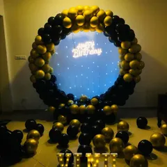 A simple yet stunning black and gold balloon ring decoration. This setup is great for smaller spaces, providing a beautiful photo backdrop with a neon sign and marquee letters without needing the full prop display.