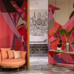 A view of the 'ClanDestine House' project, showing the relationship between the colorful mural and the monochrome staircase illustration.