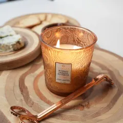 Our Bombay Orange Bourbon candle, captured here with a candle trimmer. This fragrance blends fresh orange and tangerine with the warmth of bourbon, creating a cozy and inviting atmosphere.