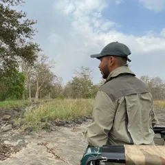 Standing in the jeep, scanning the horizon. Every safari is a new story waiting to be discovered.