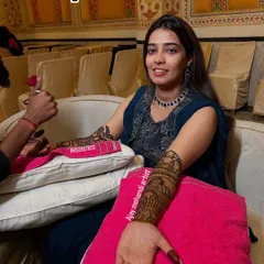 We focus on making our clients comfortable and happy during the application process. Here, a bride smiles for the camera while we carefully apply her intricate wedding henna.