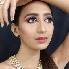 A striking glamour look featuring a vibrant pink and purple smokey eye. This style is perfect for a cocktail party or sangeet where you want your eyes to be the center of attention.
