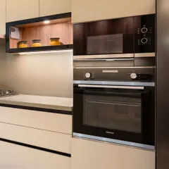 We prioritize ergonomics and functionality in our kitchen designs. Here, the built-in oven and microwave are placed at a convenient height, seamlessly integrated into the cabinetry for a clean, streamlined look.