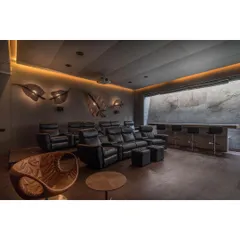 The final result is a stunning home theater where the walls are adorned with custom leaf-shaped light fixtures and the bar features our unique leaf-imprinted concrete. It's a space where art and architecture become one.