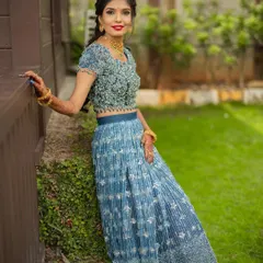 A portrait from the ring ceremony. The makeup features a bright, bold lip that adds a pop of color to the elegant blue lehenga, creating a look that is both fun and sophisticated.