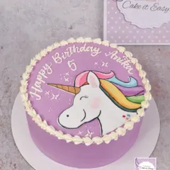 A hand-painted unicorn cake for a 5th birthday. The simple piped border lets the painted artwork shine.