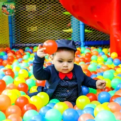 Even the littlest guests can enjoy the fun. Here, a one-year-old safely explores the soft, colorful balls in our toddler-friendly ball pit during his first birthday party.