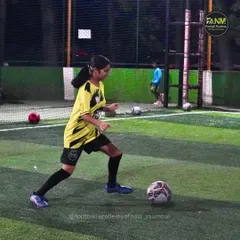 A female player demonstrates confidence and control on the ball during an evening training session.