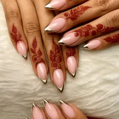 The perfect pairing of modern glam and tradition. I designed these sharp, stiletto-shaped press-ons with a gold chrome French tip to beautifully complement the intricate patterns of the bridal henna.