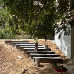 A site visit during the construction of the 'rising green' garden. This shows the hands-on process of building the stepped pathway and shaping the earth before the final planting and lawn installation.