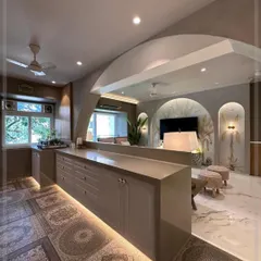 A view from the living area into the open-concept kitchen. The island serves as a beautiful and practical divider, with its routed cabinet doors and warm lighting creating an inviting atmosphere.