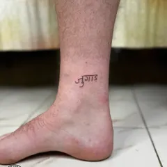 The Hindi word "Jugaad" tattooed on the ankle. This small tattoo captures a core concept of Indian resourcefulness and was created for a client from Wales who fell in love with the idea.