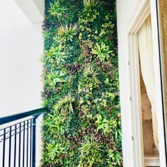 A full-height vertical garden panel makes a huge impact on this apartment balcony. The varied green textures create a stunning natural backdrop that enhances the view and provides a sense of privacy.