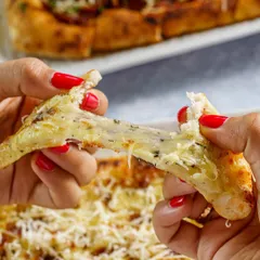 The cheese pull is the ultimate money shot for anything with cheese. This photo of a cheesy garlic bread being pulled apart is designed to create an instant craving and highlight the indulgent nature of the dish.