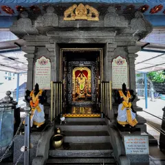 The intricately carved stone entrance to the inner sanctum of a temple, with guards and deities flanking the doorway.