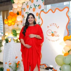The beautiful mom-to-be glows in front of the citrus-themed backdrop. Her joy is the reason we pour so much love into creating these special moments.