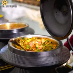 A close-up of a vibrant vegetable dish in a modern black chafing dish, part of our extensive main course selection.