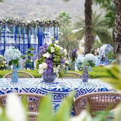 A tablescape from the Jaipur event, with a custom-printed tablecloth and floral arrangements in matching blue and white vases. The design is cohesive down to the smallest detail.