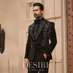 True luxury is in the details. This black velvet tuxedo features a cascade of hand-sewn silver and crystal embellishments on the lapels and shoulders, crafted for the man who appreciates timeless elegance with a modern edge.