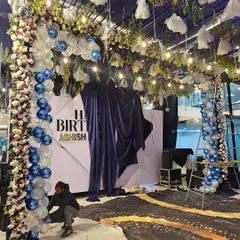 Here's a look at the setup process for a grand birthday party. My team is arranging the balloon arches and floral decorations against the custom backdrop.