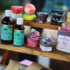 A display from an offline event showing my Hair Re-Growth Oil, bath bombs, and various soaps like the Unicorn and Charcoal bars.