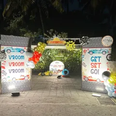 The grand entrance for this car-themed party features "Vroom Vroom" and "Get Set Go" signs, checkered flag patterns, and a starting line arch to get guests excited.