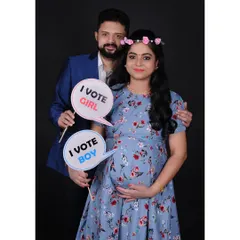 Another playful gender reveal idea where the parents "vote" for a boy or girl. These prop-based shots add a personal and creative touch to your maternity photoshoot.