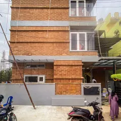 Another perspective of the Tripathy home's facade, highlighting the texture of the mud blocks and the integration of large windows for natural light.