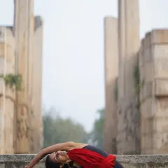 A beautiful shot of Parivrtta Janu Sirsasana against ancient stone pillars, a pose that encourages graceful opening and extension.
