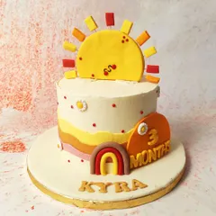 We celebrate three months of sunshine with this warm and cheerful sunrise cake. A smiling sun topper, a mini rainbow, and wavy layers of yellow and orange create a bright and happy design for a baby's milestone celebration.