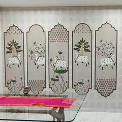 A custom Pichwai-style wallpaper installed in a dining area in Goregaon. The design features holy cows and lotus flowers arranged in decorative panels, adding a traditional and spiritual touch.