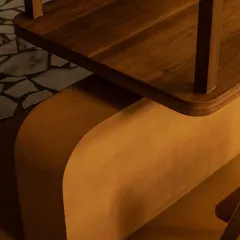 We believe in the beauty of simple forms and honest materials. This detail from the Grid Pavilion shows the gentle curve of a Jaisalmer stone base meeting a polished teak wood surface, a quiet moment of material harmony.