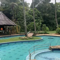 A view of our winding pool, complete with a pool bar in a thatched-roof hut. It’s a popular spot for guests to relax and enjoy the tropical resort atmosphere.
