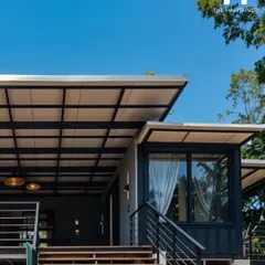 The exterior staircase and shared deck connect the different units of the Coorg project, creating a sense of community while maintaining privacy. The design is both functional and aesthetically pleasing.