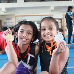 The smiles say it all. We believe every effort deserves to be celebrated, and seeing our young gymnasts proudly show off their medals from a district-level competition is our greatest reward.